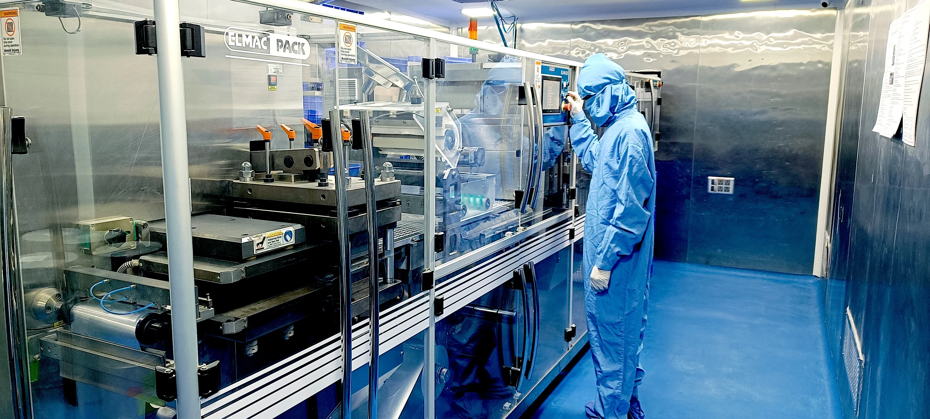 modern pharmaceutical manufacturing facility with blue accents, clean rooms and advanced equipment, professional photography
